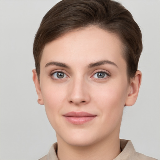 Joyful white young-adult female with short  brown hair and grey eyes