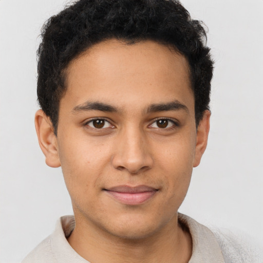 Joyful latino young-adult male with short  brown hair and brown eyes