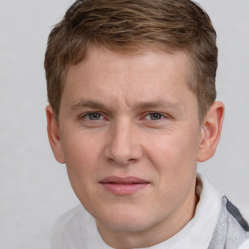 Joyful white young-adult male with short  brown hair and blue eyes