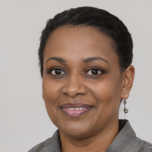Joyful black adult female with short  black hair and brown eyes