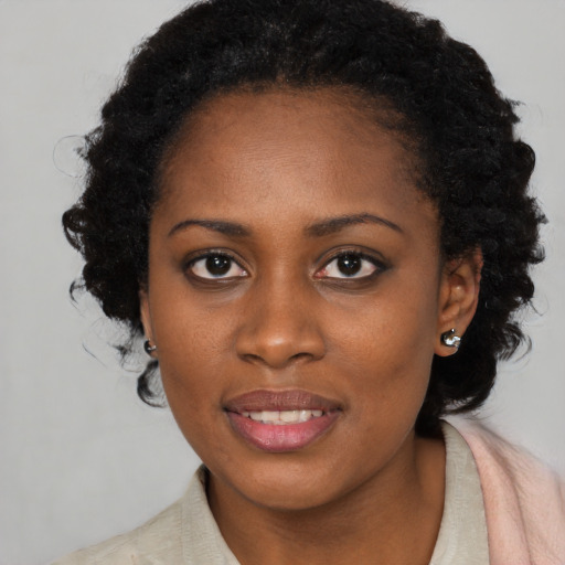 Joyful black young-adult female with long  brown hair and brown eyes