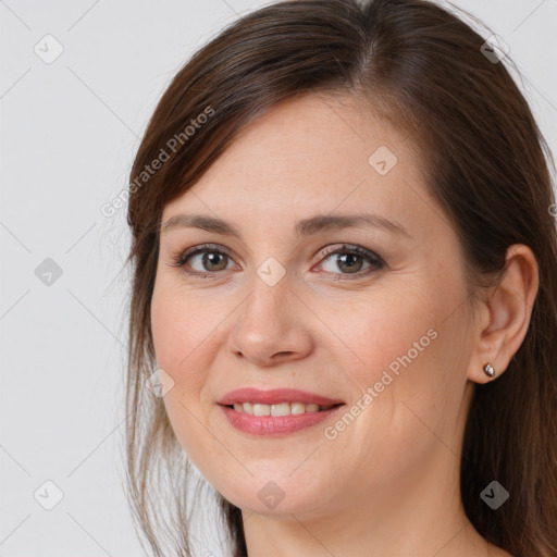 Joyful white young-adult female with long  brown hair and brown eyes