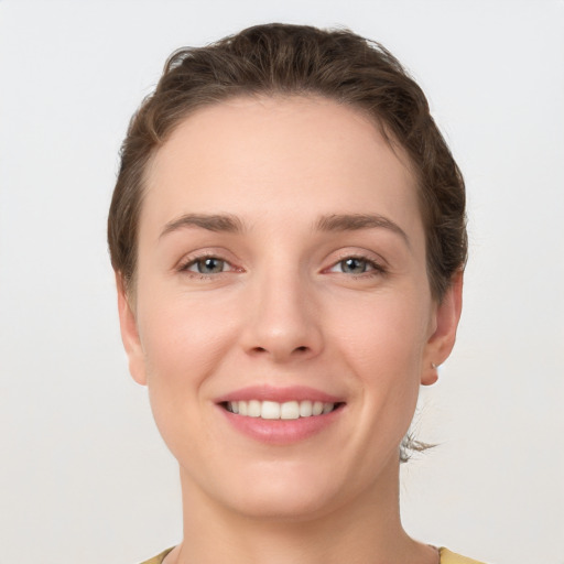 Joyful white young-adult female with short  brown hair and grey eyes