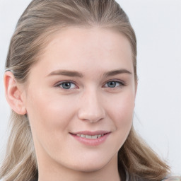 Joyful white young-adult female with long  brown hair and blue eyes