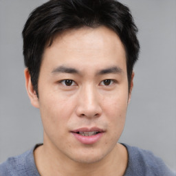 Joyful asian young-adult male with short  brown hair and brown eyes