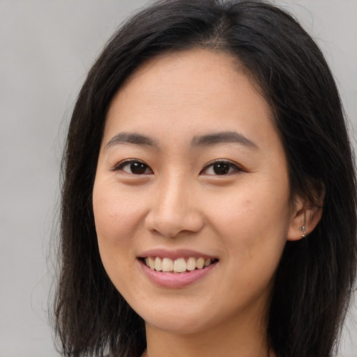 Joyful asian young-adult female with long  brown hair and brown eyes