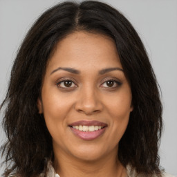 Joyful black young-adult female with long  brown hair and brown eyes