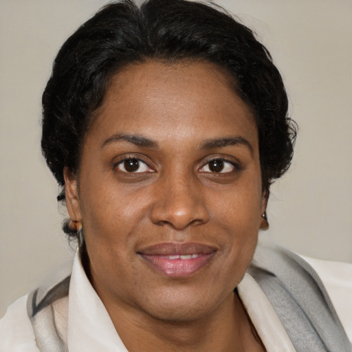 Joyful black adult female with short  brown hair and brown eyes