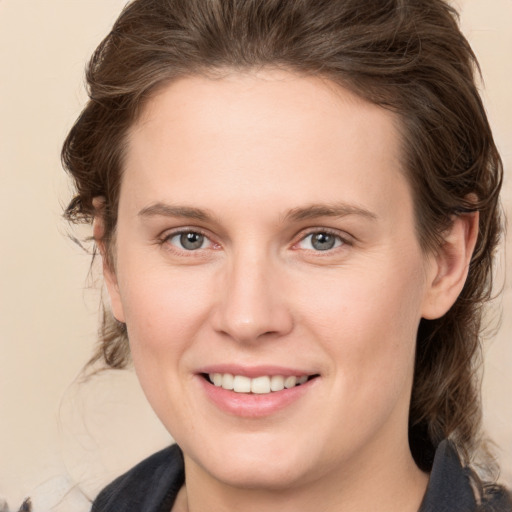 Joyful white young-adult female with medium  brown hair and grey eyes