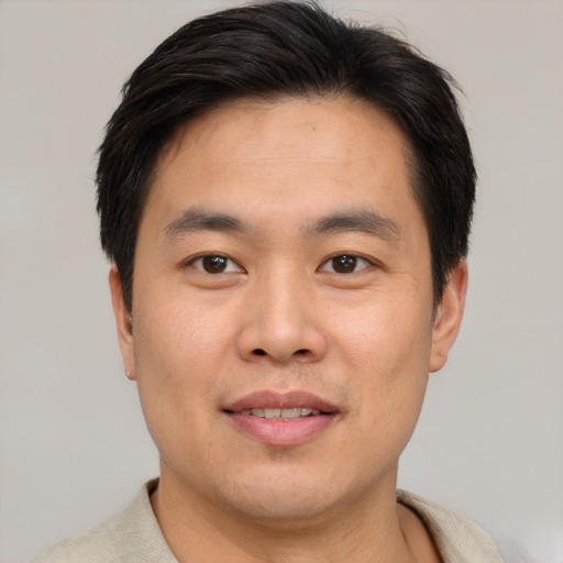 Joyful asian young-adult male with short  brown hair and brown eyes