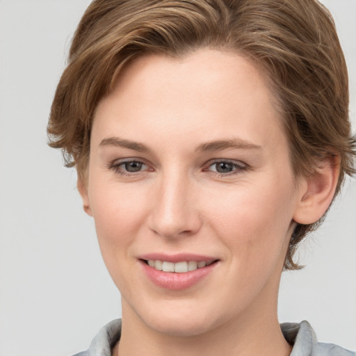 Joyful white young-adult female with short  brown hair and grey eyes