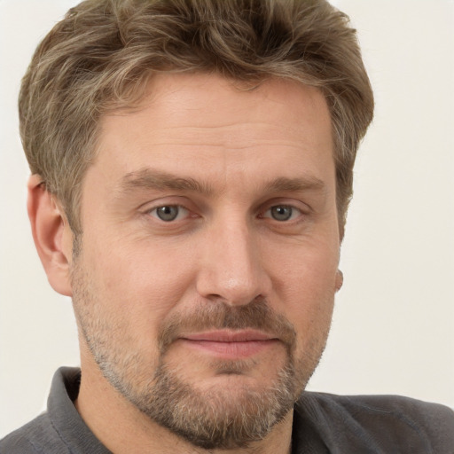 Joyful white adult male with short  brown hair and grey eyes