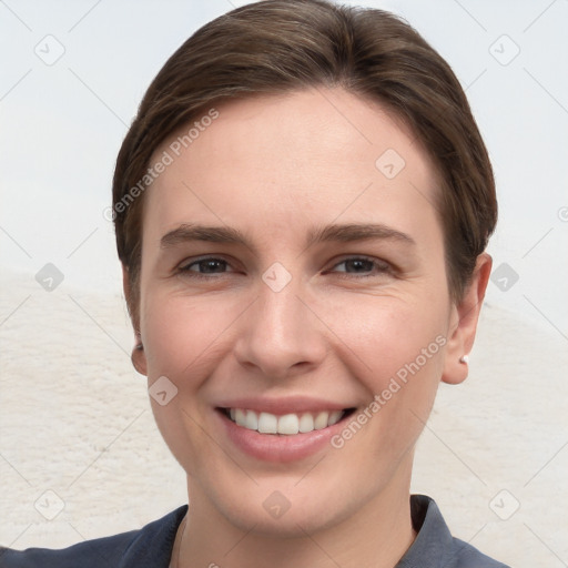 Joyful white young-adult female with short  brown hair and grey eyes