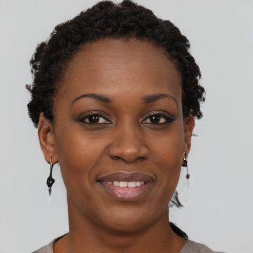 Joyful black young-adult female with short  brown hair and brown eyes