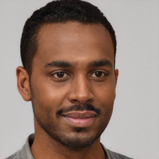 Joyful black young-adult male with short  black hair and brown eyes