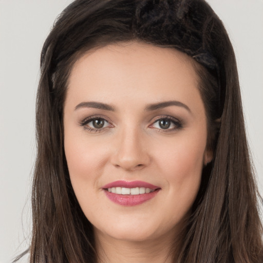 Joyful white young-adult female with long  brown hair and brown eyes