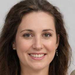 Joyful white young-adult female with long  brown hair and green eyes