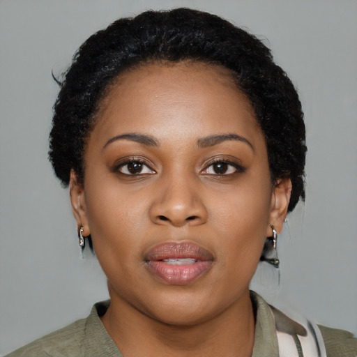 Joyful black young-adult female with short  black hair and brown eyes