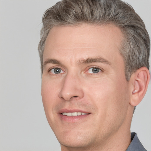 Joyful white adult male with short  brown hair and grey eyes