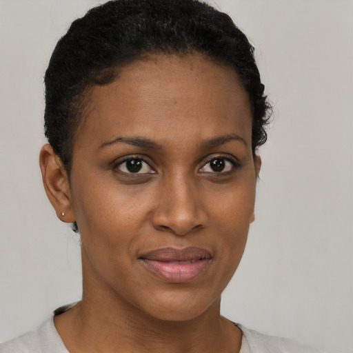 Joyful black young-adult female with short  brown hair and brown eyes