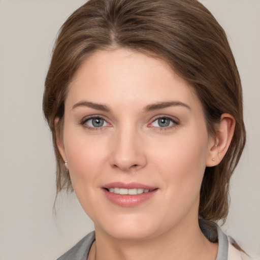 Joyful white young-adult female with medium  brown hair and grey eyes