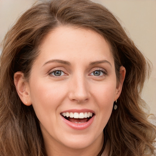 Joyful white young-adult female with long  brown hair and green eyes