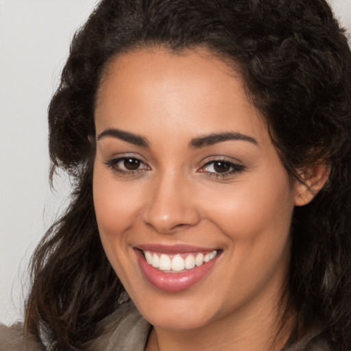 Joyful latino young-adult female with long  brown hair and brown eyes