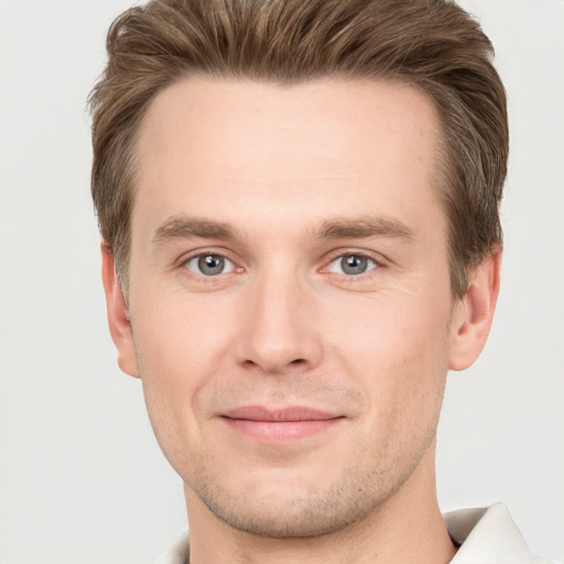 Joyful white young-adult male with short  brown hair and grey eyes