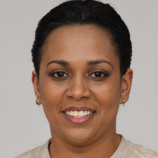 Joyful black young-adult female with short  black hair and brown eyes