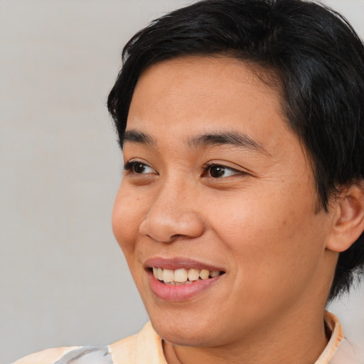 Joyful asian young-adult female with short  brown hair and brown eyes