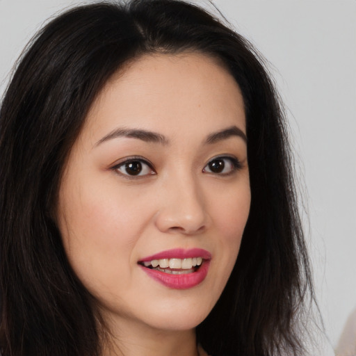 Joyful asian young-adult female with long  brown hair and brown eyes