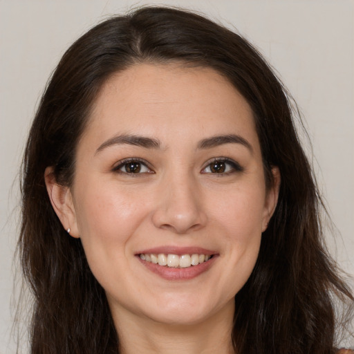 Joyful white young-adult female with long  brown hair and brown eyes