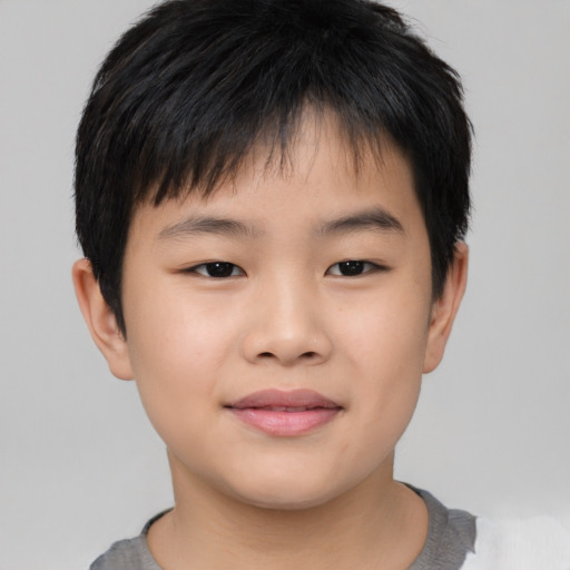 Joyful asian child male with short  brown hair and brown eyes