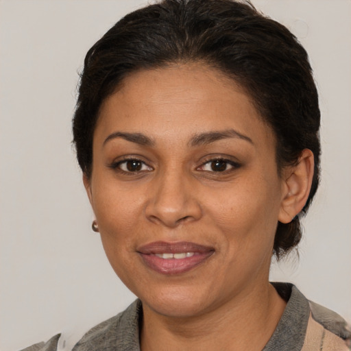 Joyful latino adult female with short  brown hair and brown eyes