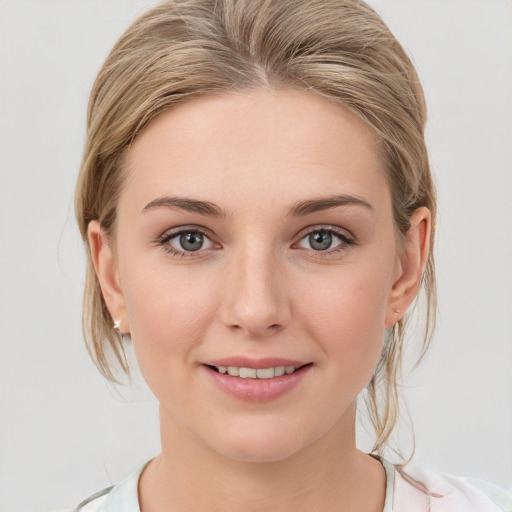 Joyful white young-adult female with medium  brown hair and grey eyes