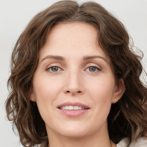 Joyful white young-adult female with medium  brown hair and green eyes