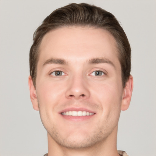 Joyful white young-adult male with short  brown hair and grey eyes