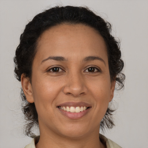 Joyful latino adult female with medium  brown hair and brown eyes