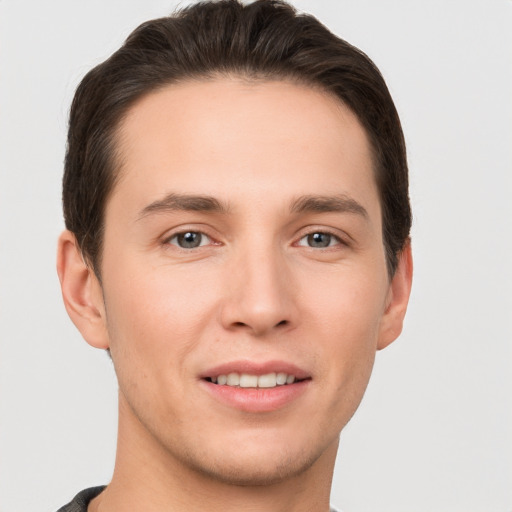 Joyful white young-adult male with short  brown hair and grey eyes