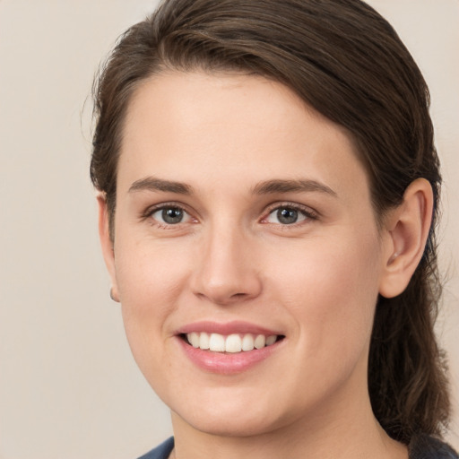 Joyful white young-adult female with medium  brown hair and grey eyes