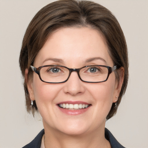 Joyful white adult female with medium  brown hair and grey eyes