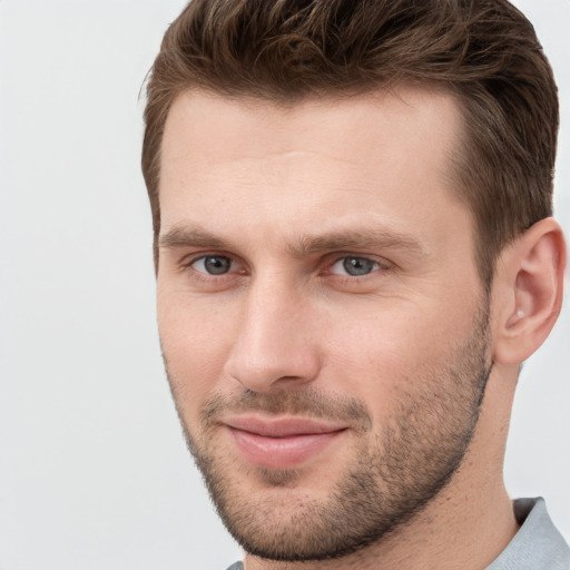 Joyful white young-adult male with short  brown hair and grey eyes