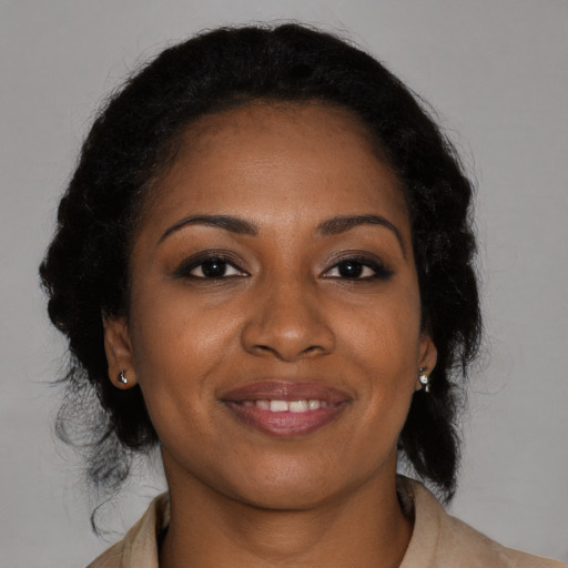 Joyful black young-adult female with medium  brown hair and brown eyes