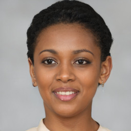 Joyful black young-adult female with short  black hair and brown eyes