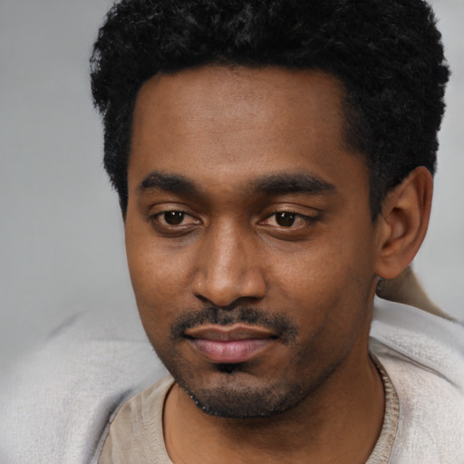 Joyful black young-adult male with short  black hair and brown eyes