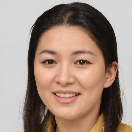 Joyful asian young-adult female with long  brown hair and brown eyes
