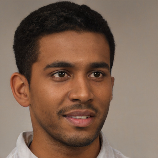 Joyful black young-adult male with short  brown hair and brown eyes