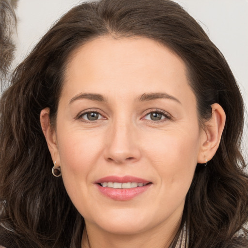 Joyful white adult female with long  brown hair and brown eyes