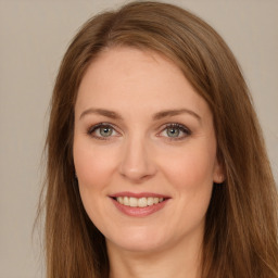 Joyful white young-adult female with long  brown hair and green eyes