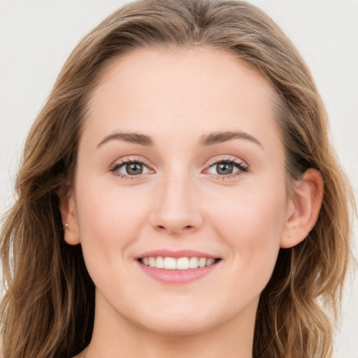 Joyful white young-adult female with long  brown hair and blue eyes